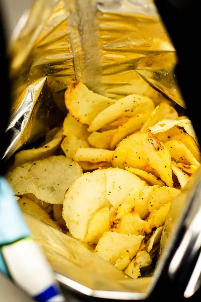 Patates cipsi dolu bir çanta. Çıtır cipsleri yakın. Pakette çıtır çıtır atıştırmalık. Sağlıksız fast food