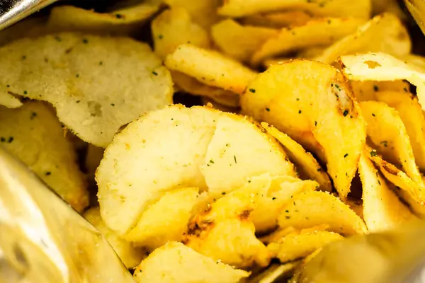 Patates cipsi dolu bir çanta. Çıtır cipsleri yakın. Pakette çıtır çıtır atıştırmalık. Sağlıksız fast food