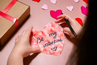 Sevgililer günü kartı hazırlayan kadın. Kalp şeklinde el yapımı tebrik kartı. Uzayı kopyala Sevgililer Günü konsepti.