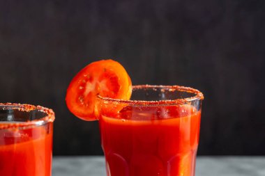 İki taze sebze kokteyli. Kırmızı kokteyl. Domates dilimli domates suyu bardakta servis edilir. Menü, barlar, restoranlar için resim
