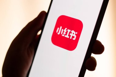 Kaliningrad, Rusya. 15/01/2025. Kadın ellerinde akıllı telefon ekranındaki kırmızı not uygulaması. Yeni Çin sosyal medya uygulamasına tıklıyorum. ABD 'de Tik tok yasağı.