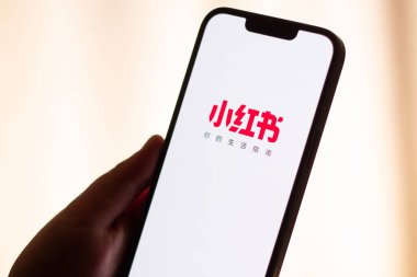 Kaliningrad, Rusya. 15/01/2025. Kadın ellerinde akıllı telefon ekranındaki kırmızı not uygulaması. Yeni Çin sosyal medya uygulamasına tıklıyorum. ABD 'de Tik tok yasağı.