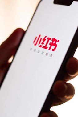 Kaliningrad, Rusya. 15/01/2025. Kırmızı nota uygulamasının dikey görüntüsü kadının elinde akıllı telefon ekranında. Yeni Çin sosyal medya uygulamasına tıklıyorum. ABD 'de Tik tok yasağı.