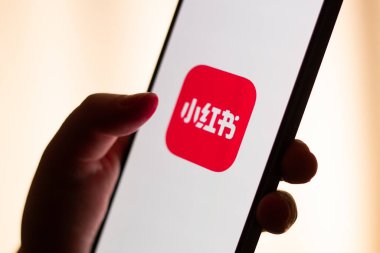 Kaliningrad, Rusya. 15/01/2025. Kadın ellerinde akıllı telefon ekranındaki kırmızı not uygulaması. Yeni Çin sosyal medya uygulamasına tıklıyorum. ABD 'de Tik tok yasağı.