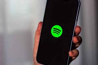 Kaliningrad, Rusya 14.01.25 SPOTIFY uygulamalı akıllı telefonu ekranda tutan kadın. Çevrimiçi müzik uygulaması.