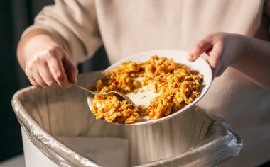 Yemek artıklarıyla çöpleri çöpe atan bir kadın. Gübre. Çevre dostu. Yiyecek israfını durdurun..