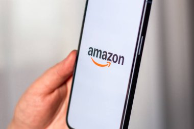 Kaliningrad, Rusya 14.01.25 AMAZON uygulamalı akıllı telefonu ekranda tutan kadın. Çevrimiçi alışveriş uygulaması.