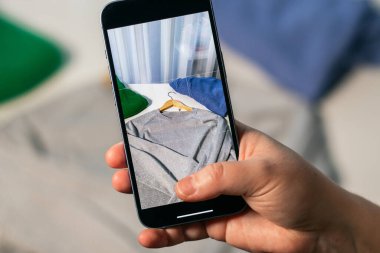 Kullanılmış süveterin fotoğrafını çekiyorum. İkinci el dükkanında satmak için kıyafet hazırlıyorum. İkinci el ve yeniden satış konsepti. Kıyafet bağışı.