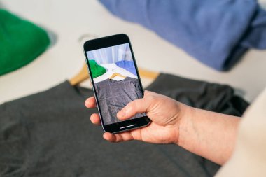 Kullanılmış süveterin fotoğrafını çekiyorum. İkinci el dükkanında satmak için kıyafet hazırlıyorum. İkinci el ve yeniden satış konsepti. Kıyafet bağışı.