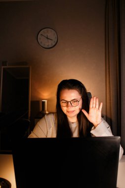 Gülümseyen serbest çalışan bir bayan müşteriyle çevrimiçi konferans görüşmesi yapıyor. Uzak görev konsepti