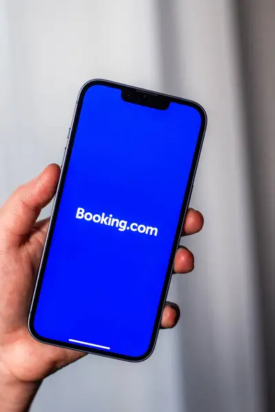 Kaliningrad, Rusya 14.01.25 BOOKINGCOM uygulaması olan akıllı telefonu ekranda tutan kadın. Daire ve otel araması. Seyahat planlama kavramı.