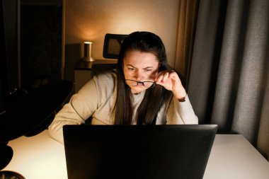 Akşam geç saatlerde ev ofisinde bilgisayar başında çalışan bir kadın. İşle ilgili sorunları çözmeye çalışan konsantre kadın bir serbest yazar. Çalışmaktan ve yorgunluktan acı çekmekten