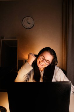 Genç iş kadını bilgisayar ekranına bakıyor ve küçük işletmesinin ilk satışlarını görüyor. Dizüstü bilgisayarı olan heyecanlı ve mutlu bir beyaz kadın. Ürün satan yeni girişimci