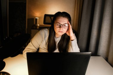 Akşam geç saatlerde ev ofisinde bilgisayar başında çalışan bir kadın. İşle ilgili sorunları çözmeye çalışan konsantre kadın bir serbest yazar. Çalışmaktan ve yorgunluktan acı çekmekten