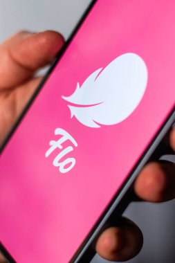 Kaliningrad, Rusya 14.01.25 FLO uygulama logosuna sahip akıllı telefonu ekranda tutan kadın. Kadın kontrolü, yumurtlama, hamilelik. Kadın sağlığı kavramı.