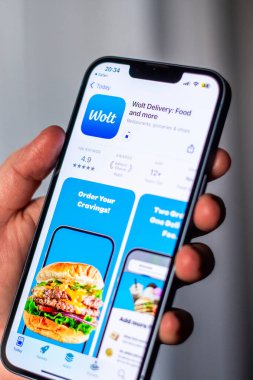 Kaliningrad, Rusya 14.01.25 - iPhone 'u tutan ve uygulama mağazasından WOLT uygulaması indiren kadın. Taksi ve teslimat uygulaması