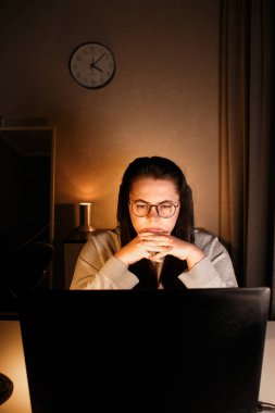 Akşam geç saatlerde ev ofisinde bilgisayar başında çalışan bir kadın. İşle ilgili sorunları çözmeye çalışan konsantre kadın bir serbest yazar. Çalışmaktan ve yorgunluktan acı çekmekten