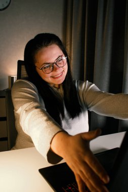 Neşeli milenyum kadını, bilgisayarını kullanarak arkadaşlarıyla görüntülü konuşma yapmaktan zevk alıyor. Hareketli ve gülümseyen. Uzakta yaşayan arkadaşlarla konuşmak. Uzun mesafeli dostluğa değer veren