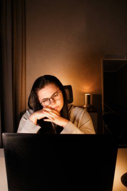 Akşam geç saatlerde ev ofisinde bilgisayar başında çalışan bir kadın. İşle ilgili sorunları çözmeye çalışan konsantre kadın bir serbest yazar. Çalışmaktan ve yorgunluktan acı çekmekten