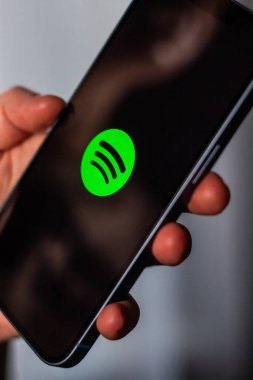 Kaliningrad, Rusya 14.01.25 SPOTIFY uygulamalı akıllı telefonu ekranda tutan kadın. Çevrimiçi müzik uygulaması.