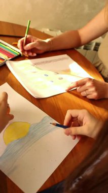 Anne, kızına evde oturarak resim çizmeyi öğretiyor. Aile sevgisinin samimi bir fotoğrafı. Eğitim, ebeveynlik ve yaşam tarzı içeriği için