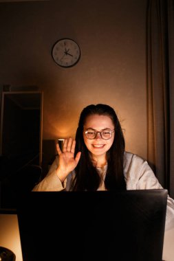 Gülümseyen serbest çalışan bir bayan müşteriyle çevrimiçi konferans görüşmesi yapıyor. Uzak görev konsepti