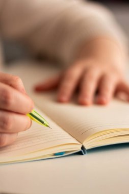 Günlüğe kişisel düşünceler yazan el yazısının ılık tonlu görüntüsü. Sıcak atmosfer için bulanık arkaplan