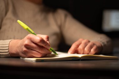 Günlüğe kişisel düşünceler yazan el yazısının ılık tonlu görüntüsü. Sıcak atmosfer için bulanık arkaplan