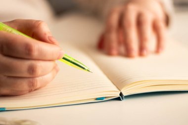 Günlüğe kişisel düşünceler yazan el yazısının ılık tonlu görüntüsü. Sıcak atmosfer için bulanık arkaplan