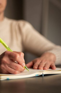 Günlüğe kişisel düşünceler yazan el yazısının ılık tonlu görüntüsü. Sıcak atmosfer için bulanık arkaplan