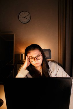 Odaklanmış iş kadını bilgisayarla sanal iş görüşmesi yapıyor. Evde oturan serbest çalışan, video konferansına katılıyor