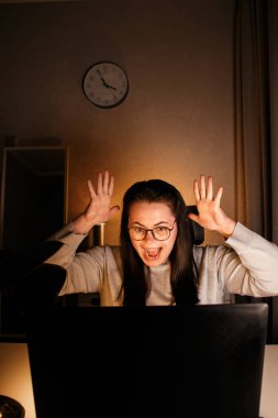 Milenyum kadınları ev ofisteki zaferlerini kutluyor, iş kadını laptopla çalışıyor, sevinçle el ele tutuşuyor, tatmin oluyor, mükemmel sonuçlar elde ediyor.