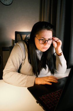 Akşam geç saatlerde ev ofisinde bilgisayar başında çalışan bir kadın. İşle ilgili sorunları çözmeye çalışan konsantre kadın bir serbest yazar. Çalışmaktan ve yorgunluktan acı çekmekten