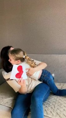 Tasasız 4 yaşında açık renk saçlı bir kız büyük bir gülümsemeyle kanepeye atlayarak kurallara karşı geliyor. Saf çocukluk anları