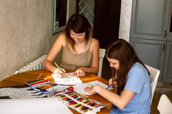 Kız ve annesi resim yapmaya dalmışlar, hatıralar edinmişler. Sıcak ve samimi aile anları. Ebeveynlik ve annelik kavramı