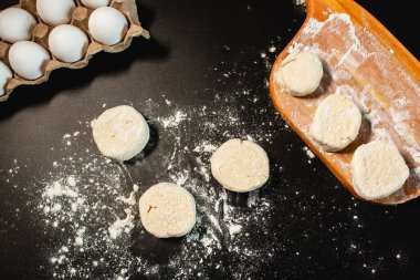 Syrniki yapma süreci. Kaymak hamurundan şerbet oluşturun. Siyah yüzeyin en üst görüntüsü. Rus mutfağı.