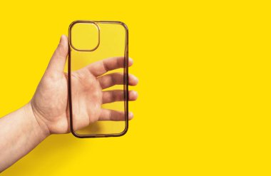 Eski ve kirli telefon kılıfı parlak sarı arka plana karşı, temiz tasarım ve modern estetik sergileniyor, akıllı telefon koruması ve stil geliştirme için ideal.