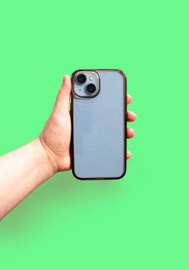 Eski ve kirli telefon kılıfı parlak yeşil arka planda sergileniyor. Ürün tesislerini sergilemek için mükemmel..