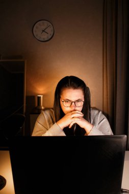 Odaklanmış iş kadını bilgisayarla sanal iş görüşmesi yapıyor. Evde oturan serbest çalışan, video konferansına katılıyor