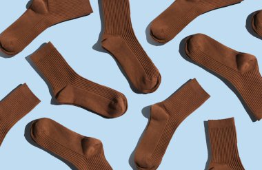 Açık mavi arka planda, açık mavi desenli kahverengi çoraplar moda ve tekstil uygulamaları için idealdir..