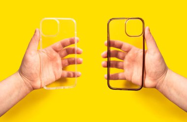 Elleri saydam iki telefon kılıfı, biri temiz diğeri de açık sarı arka planda kirli. Yeni ve eski akıllı telefon dosyalarının karşılaştırılması.