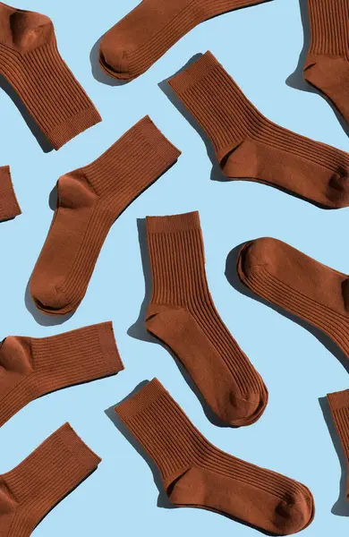 Açık mavi arka planda şakacı desenli kahverengi çoraplar, moda ve tekstil uygulamaları için ideal desen ve tasarım sergileniyor. Dikey