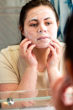 Kadının nazikçe yüzünü temizleyen ve temizleyici köpükle masaj yapan yüzünün yan görüntüsü. Güzellik markaları, cilt bakımı adımları veya hijyenle ilgili içerikler için kullanışlı. Uluslararası kişisel bakım günü