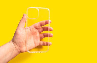 Açık sarı arka plan, temiz tasarım ve modern estetik sergilenen şeffaf telefon kılıfı, akıllı telefon aksesuar dükkanları için görüntü