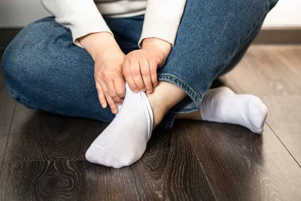 Kadının ayakları temiz beyaz çoraplar içinde, giyinirken yakalanmış. Ayakkabı reklamları, çorap markaları veya günlük yaşam tarzı içeriği