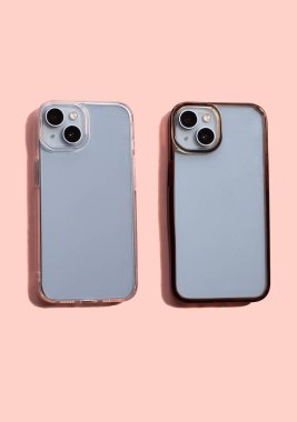 Pembe arka plandaki yeni ve eski telefon kılıflarının karşılaştırılması. Akıllı telefon koruma aygıtları
