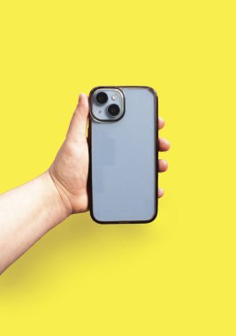 Sarı arka planda eski ve kirli bir telefon kılıfı var. Her gün akıllı telefon aksesuarları kullanılıyor.