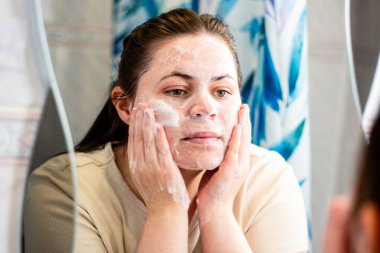 Sabah cilt temizleme rutini: kadın yüz temizleme rutininin ilk adımı. Cilt bakımı için uygun içerik. Uluslararası kişisel bakım günü