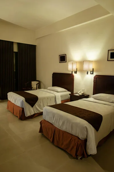 hotel room with two single beds, dim lights interior
