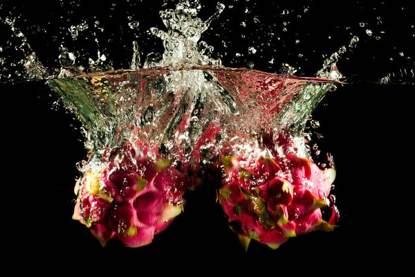 Dragon Fruit Falling into the water. Splash Drops, Bubbles and Clear Background